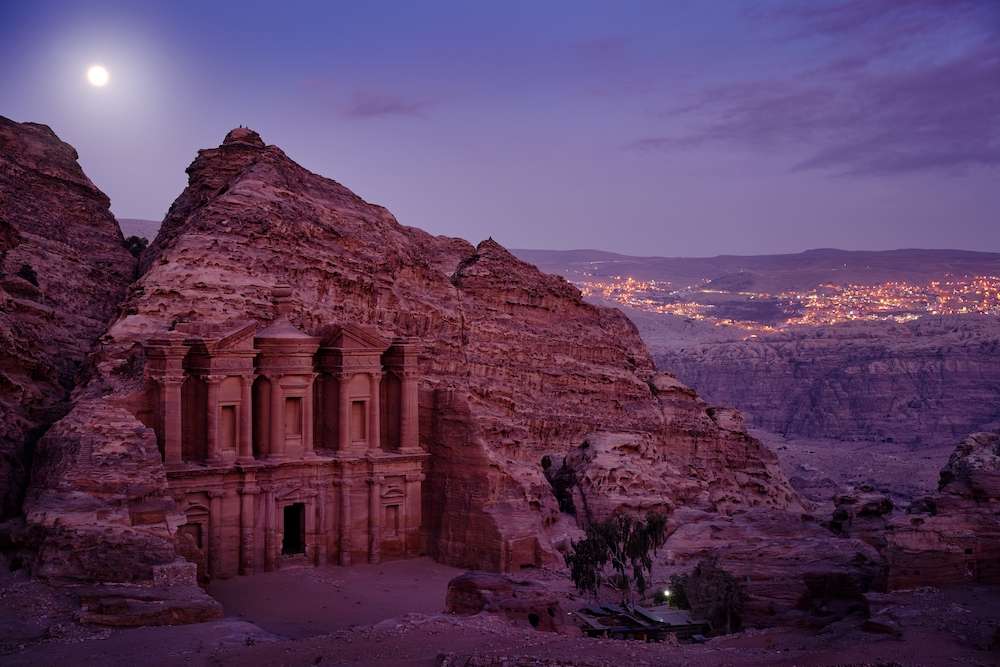 Stone Monastery in rock, Petra in Jordan. Red rock landcape. Petra historical sight - Ad Deir Monastery with full moon during the night. Evening light in nature. Travel in Jordan, Arabia in Asia.