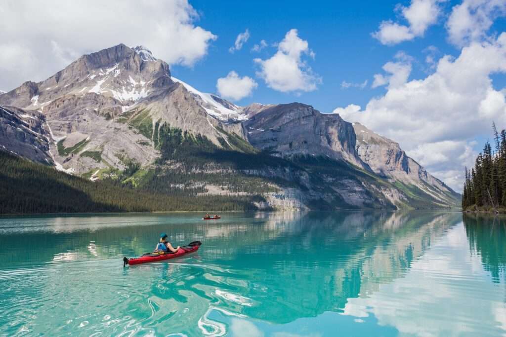 A kayaker and a canoer on Maligne Lake. / Kayakiste et canoéiste naviguant sur le lac Maline