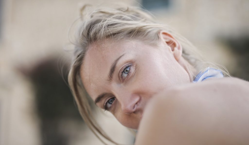Woman With Mouth Covered by Shoulder